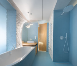 Pohled do koupelny, u vany otvíravé okno, které dovnitř propouští světlo a dá se ním větrat. ("Open space" byt v Hodoníně od Atel!er)