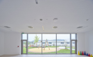 Architekti využili svažitý terén, a třípodlažní budovy tak působí dojmem dvoupodlažní stavby. (Nová škola Via v Berouně; OVA )