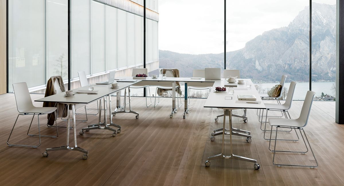 Leštěné hliníkové stoly s nohami ve tvaru C a deskami v barvě Designer White. Díky kolečkům je pojízdný.