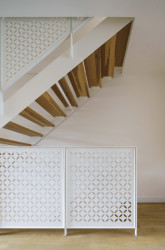 Mezi podlažími se chodí po schodišti, které dostalo nové ocelové zábradlí s vypalovaným vzorem. (Bydlení v řadovém domě v Praze-Strašnicích, BY architects)