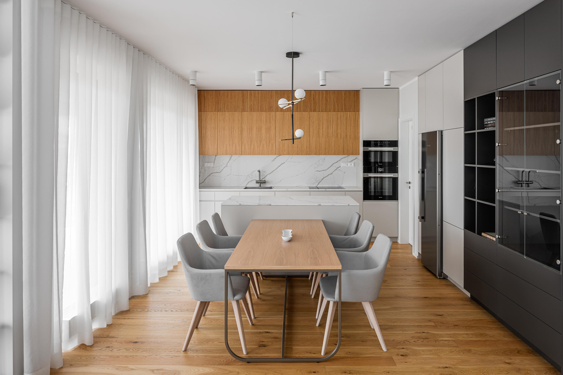 Interiér rodinného domu v Berouně od studia Ambience Design - pohled do kuchyně s deskou a obkladem TechniStone Crystal Calacatta Silva