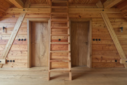 Obklad stěn je ze dřeva, část ho pochází z původní chalupy. (Chalupa Wunderbaude, A1Architects)