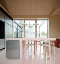 Autorský interiér s mnoha originálními řešeními. Například: na podlahu z růžového teraca navazuje stůl ze stejného materiálu. (Víkendový dům nad přehradou, NOIZ architekti)