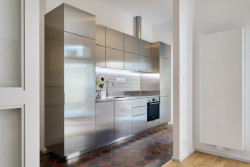 Byt Nusle, Amulet + T. Melková: Kuchyň nově doplnil dominantní kuchyňský box, jež svým povrchem z nerezové oceli dominuje prostoru.