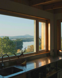 Po pravé ruce lemuje celou zeď nerezová kuchyňská linka s vybavením, o kterém se sázavským chatařům může jen zdát.