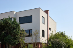 Změnil se také tvar okenních otvorů a zmizely úzké balkony. (Řadový dům v Čimicích, Plus One Architects)