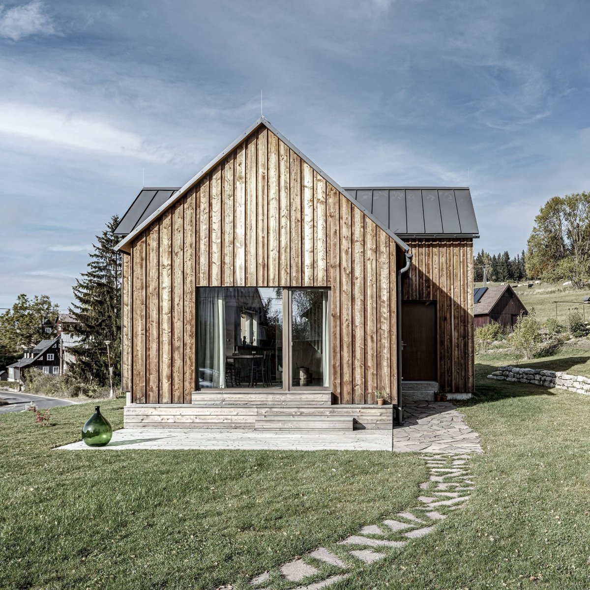Oproti okolním domům je ale domek mnohem drobnější. Architekti se ho prý snažili navrhnout co nejvíc úsporně. (Chata v Kořenově, Facha architekti)