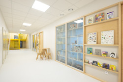 Prosklené stěny mezi třídami prostor ještě více otevírají a sousední knihovna mu dodává útulnost. (ZŠ Jinotaj ve Zlíně)