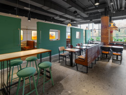 Obklady jsou ručně natírané zelenou, která byla zaznamenána na historických fotografiích. Stejnou barvu mají i čalouněné taburety Spot od LD Seating. (Bombay Express; Studio archicraft)