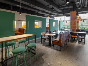 Obklady jsou ručně natírané zelenou, která byla zaznamenána na historických fotografiích. Stejnou barvu mají i čalouněné taburety Spot od LD Seating. (Bombay Express; Studio archicraft)