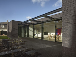 Obývací pokoj uzavírá prosklená stěna. (Rodinný dům v Řepích, Stempel & Tesař architekti)