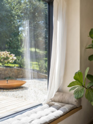 Celý interiér zútulňují nízké okenní parapety, které fungují jako pobytová okna a zároveň jako jeden velký schod do zahrady.