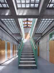 Interiéru dominuje pohledový beton, dřevo a sklo. Barevnými prvky jsou pak zábradlí a kuželové akustické prvky. - Středisko správy a údržby dálnice, Přerov, Pelčák a partner architekti