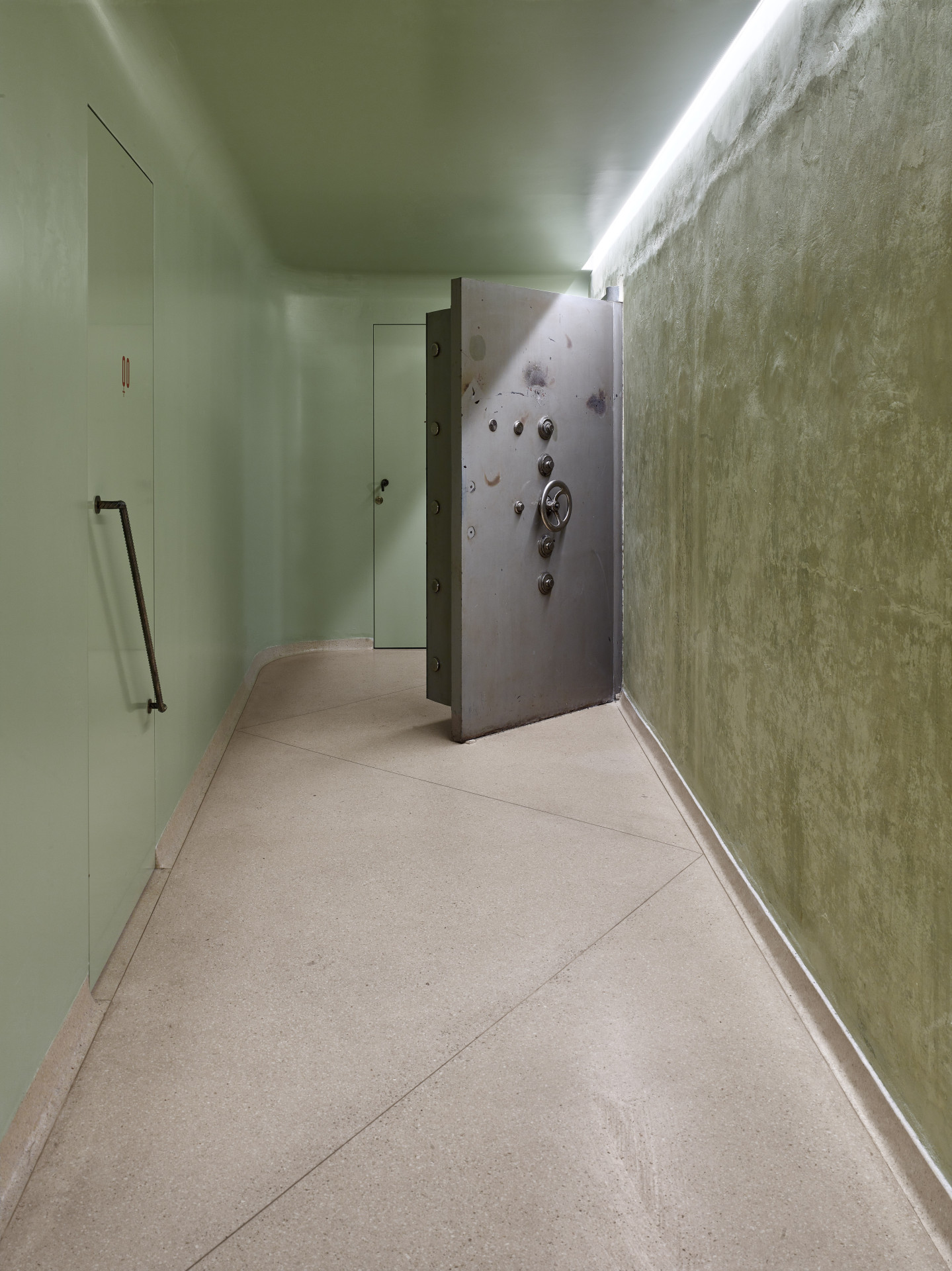 Masivní dveře trezoru, které tak dodnes připomínají původní funkci prostoru, potkáte při cestě na toalety