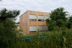 Rozšíření modulární školy Praha - Petrovice, Starý & Partner: Škola svým vzhledem působí v zahradě velice nenápadně