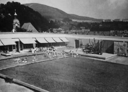 Pohled na střešní terasu s travnatou plochou a brouzdalištěm pro potřeby mateřské školy.