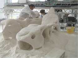 Obr. 22: Odstraňování přebytečného písku po dokončení 3D tisku spojováním prášku technologií D-Shape, Itálie / Velká Británie,