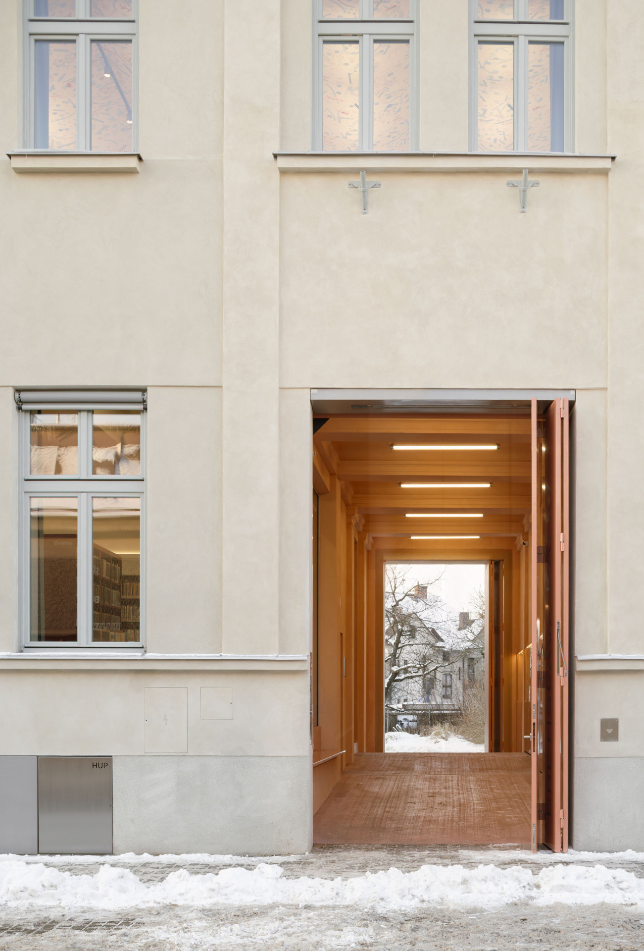 Dům původně neměl klasické dveře do ulice, ale průjezd – ten zde zůstal, nově však získal parametry reprezentativního vchodu. (Knihovna v Červeném Kostelci; Papundekl architekti)