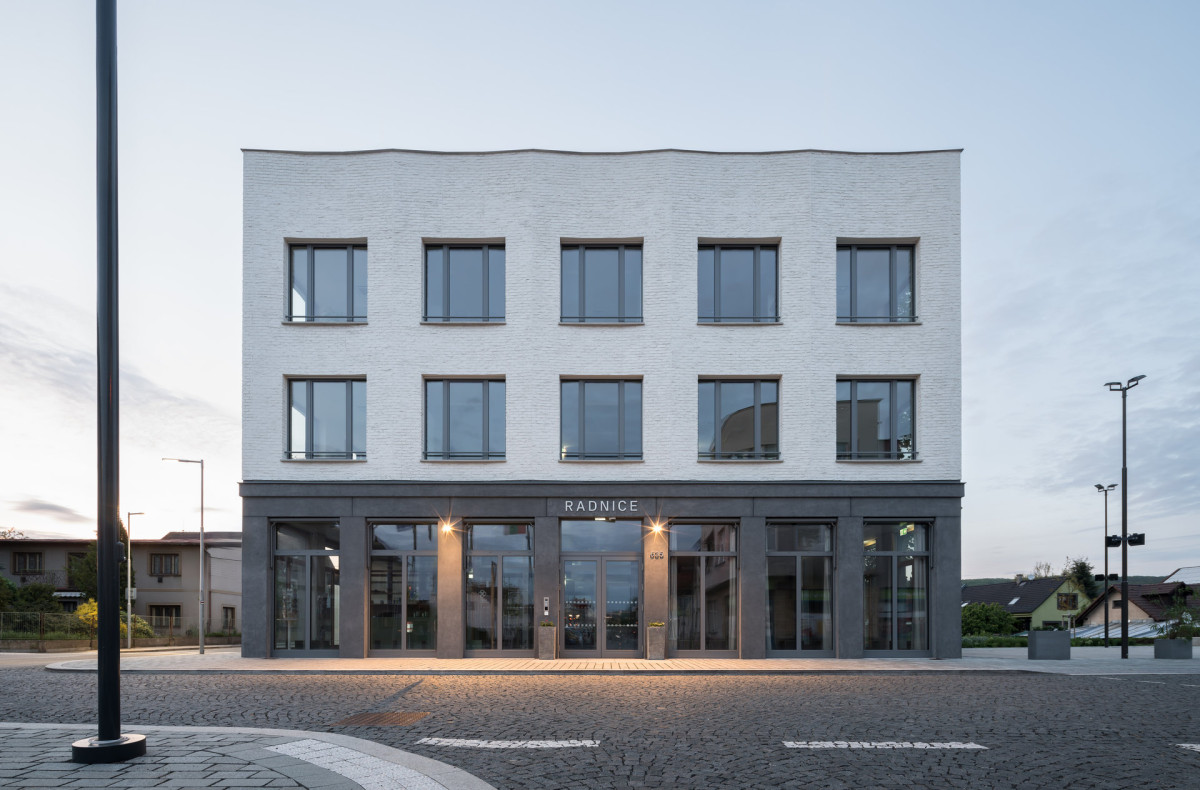 Detail vztahu budovy k náměstí - objekt působí jako přirozený organizující prvek veřejného prostoru. (Nová radnice s plastickou fasádou; re:architekti)