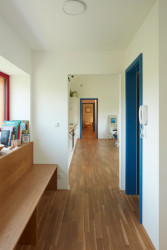 Celé obytné podlaží propojuje dlouhá chodba orientovaná na sever. (Rodinný dům v Řevnicích, 0,5 studio)