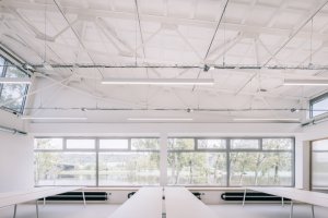 Zde se původně nacházela jídelna, dnes je to otevřený prostor kanceláří s vysokými stropy. (Ateliér v panelárně od A8000)