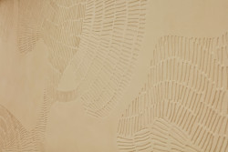 Pracovalo se tady s přírodními materiály, na jedné ze stěn je hliněná omítka s vyškrabaným obrazem. (Quis Yoga Studio v Praze-Petřinách, MENU architekti)