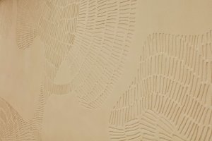 Pracovalo se tady s přírodními materiály, na jedné ze stěn je hliněná omítka s vyškrabaným obrazem. (Quis Yoga Studio v Praze-Petřinách, MENU architekti)