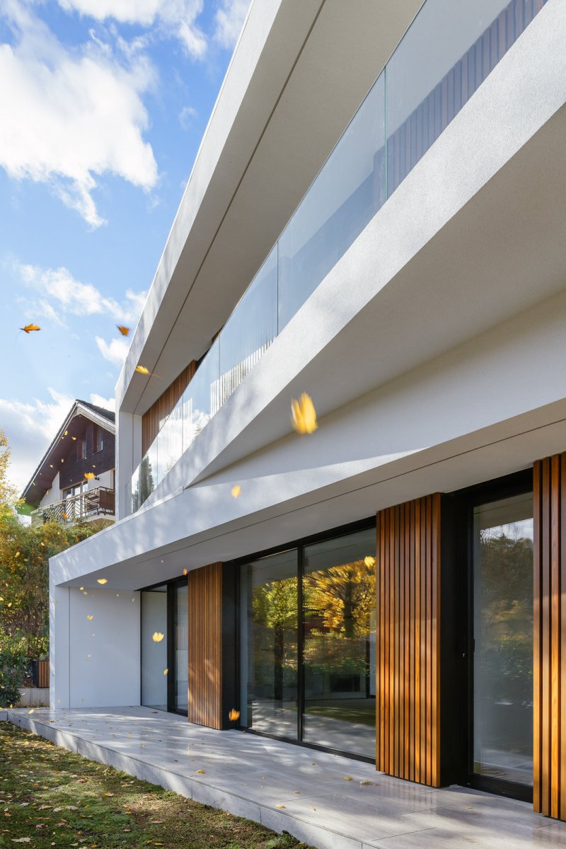 Pohled na jižní terasu v prvním nadzemním podlaží, kde se nachází obývací místnosti s kuchyní. (Block House v Šáreckém údolí v Praze; Studio MA)