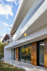 Pohled na jižní terasu v prvním nadzemním podlaží, kde se nachází obývací místnosti s kuchyní. (Block House v Šáreckém údolí v Praze; Studio MA)