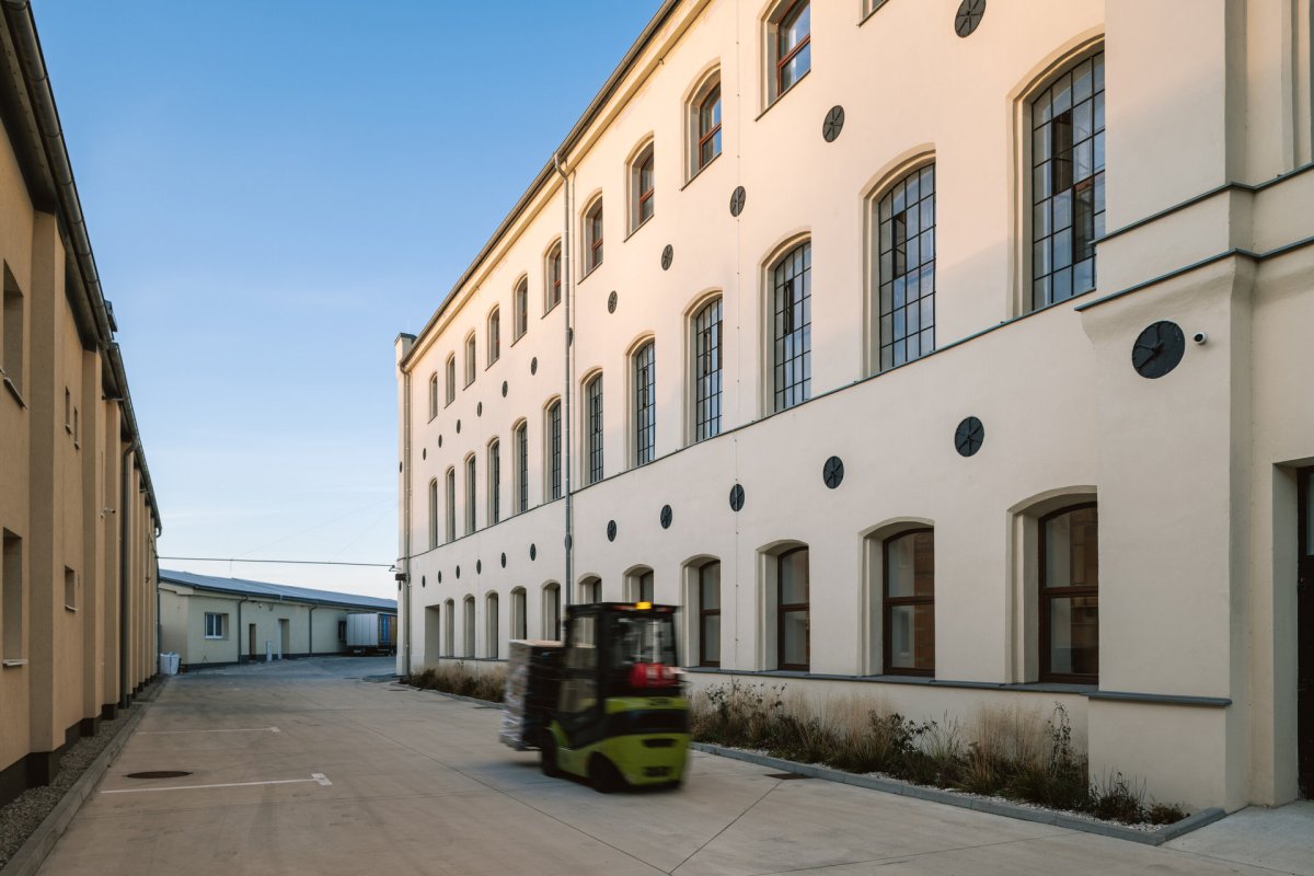 Továrna po rekonstrukci. Na fasádě jsou zachované reliéfy s květem lnu. (Rekonstrukce přádelny v Kežmarku; BEEF Architekti)