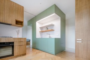 Kuchyně. Skříň v popředí ukrývá lednici. (Nová dispozice bytu na Vinohradech; Architéka)
