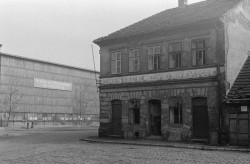 Pohled z Partyzánské ulice na výrobní halu před výstavbou holešovické předložky. Na průčelí haly je patrný nápis „Pod vedením KSČ za štastnou budoucnost našeho pracujícího lidu.“ Foto Jaroslav Janula, nedatováno, zdroj: http://prazsky.denik.cz/galerie/stinadla_serial_praha.html?mm=2167747& photo=15