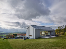 Při pohledu na dům z horní části pozemku se odhaluje jen komorní hmota se sedlovou střechou. (Rodinný dům u Klatov; Stempel Tesař architekti )