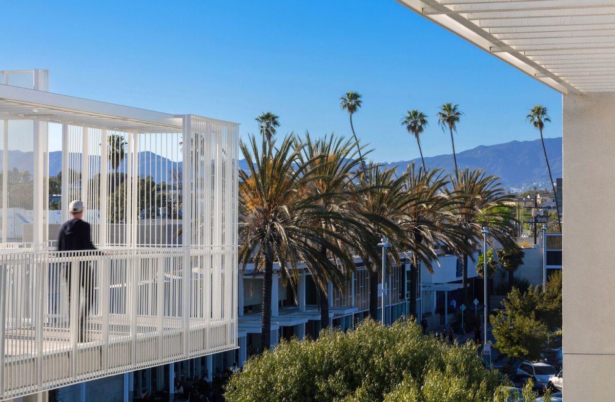 Komplex je obklopen zelení a palmami s výhledem na horské hřebeny. (Rose Apartments v Los Angeles, Brooks & Scarpa)