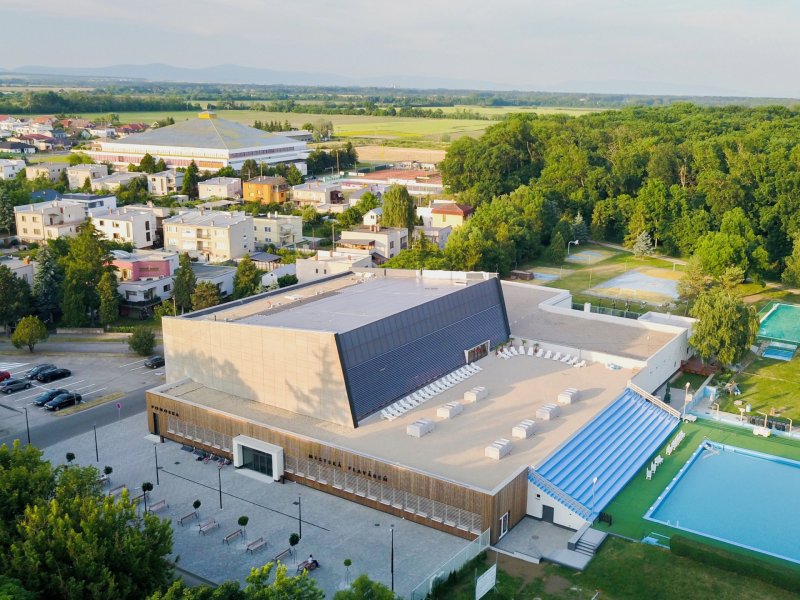 Bazén se nachází na předělu města a přírody a přiléhá k němu ještě venkovní koupaliště