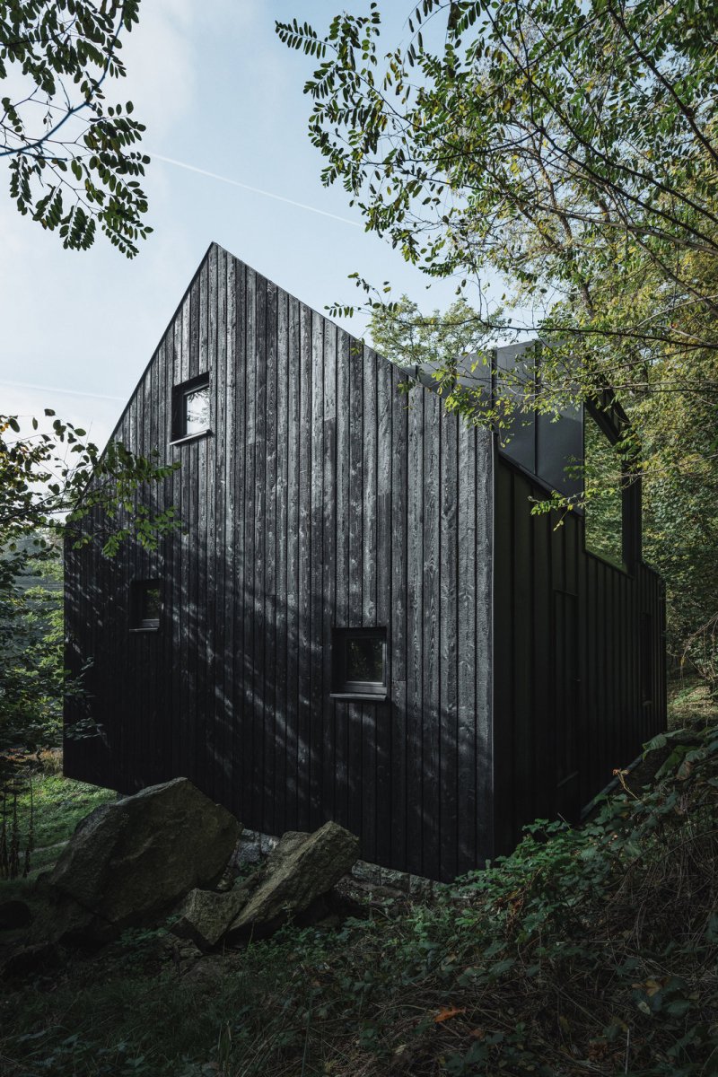 Opálená fasáda z modřínových prken (Chata u Sázavy mezi skálou a řekou; Mimosa Architekti)