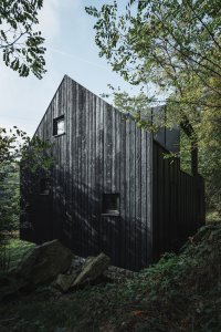 Opálená fasáda z modřínových prken (Chata u Sázavy mezi skálou a řekou; Mimosa Architekti)