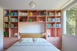 Pohled do ložnice, které dominuje růžová nábytková stěna. (Byt v paneláku od hurá studio)