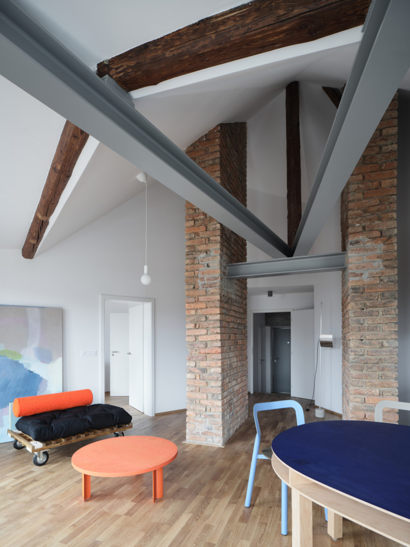 Silnými vizuálními dominantami interiéru jsou původní hrubé cihelné zdivo a pohledové ocelové nosníky. (Nástavba Harfa; matěj šebek architekti)