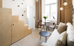 Garsonka "U Výstaviště" v Praze-Holešovicích, DesignPro: Vstupuje se na něj po schodišti, které zároveň slouží jako úložný prostor, jsou v něm knihy, lednička i spíž