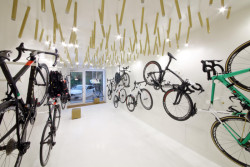Cyklobutik L27, P6PA+Architects: Mosazné osvětlení nechali architekti vyrobit na míru této prodejně. Má evokovat výplet ráfků kol