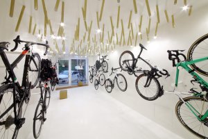 Cyklobutik L27, P6PA+Architects: Mosazné osvětlení nechali architekti vyrobit na míru této prodejně. Má evokovat výplet ráfků kol