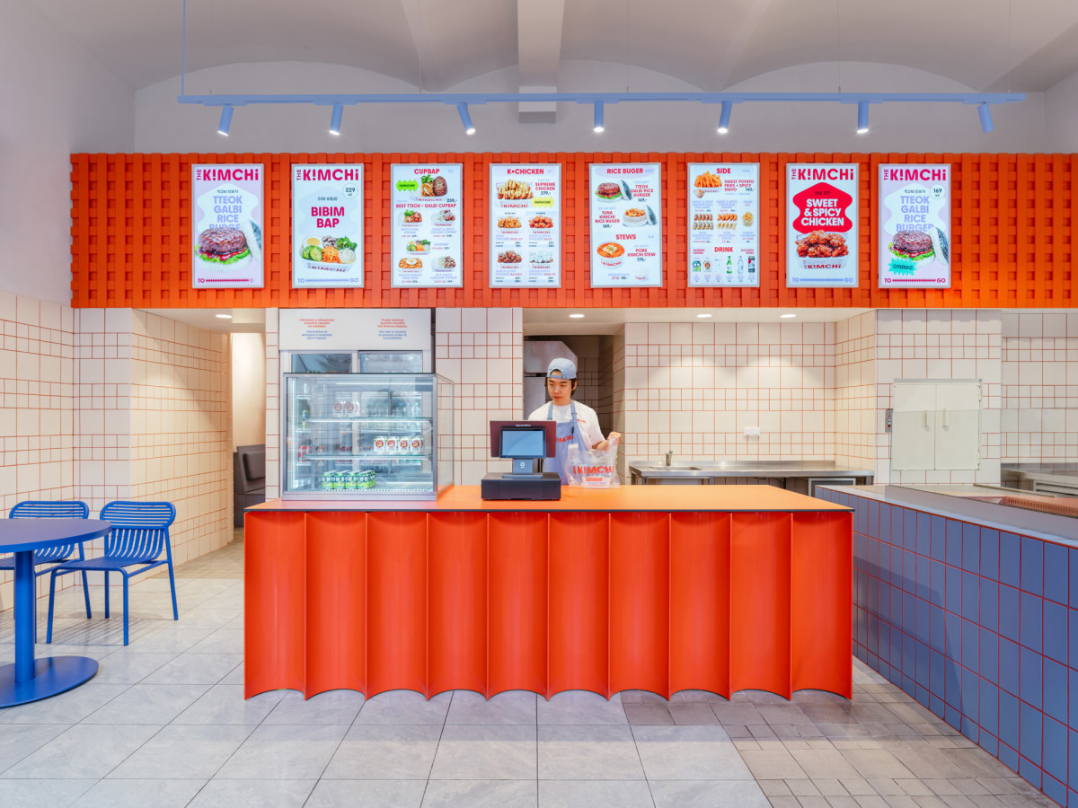 Motiv dynamické vlnovky inspirované korejskou vlajkou sjednocuje poutač, výdejní pult i grafiku interiéru. (The Kimchi; SOA architekti)