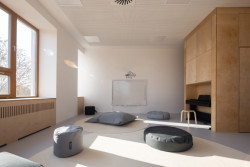 Učebny jsou střídmé, neutrální barevnost má nechat vynikat hračky a malovánky dětí. Po nábytku na míru se dá lézt a vzniklo taky spoustu šikovných úložných prostorů, třeba nika na piano nebo skříň na matrace.