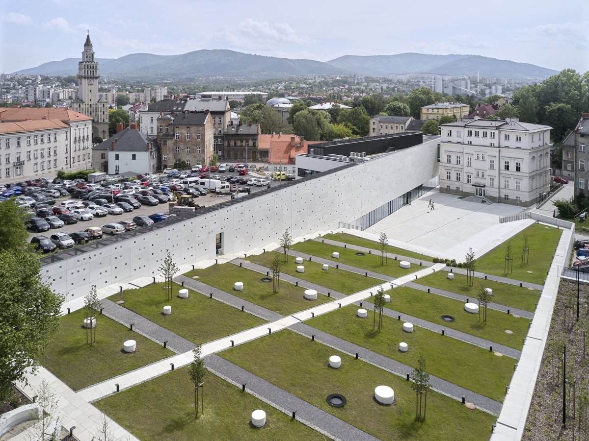 Za muzejními budovami vzniklo vydlážděné náměstíčko, které přechází do terasovité zatravněné zahrady. (Interaktivním centru pohádek a animace OKO v Bílsko-Bělé v Polsku, Nizio Design International)