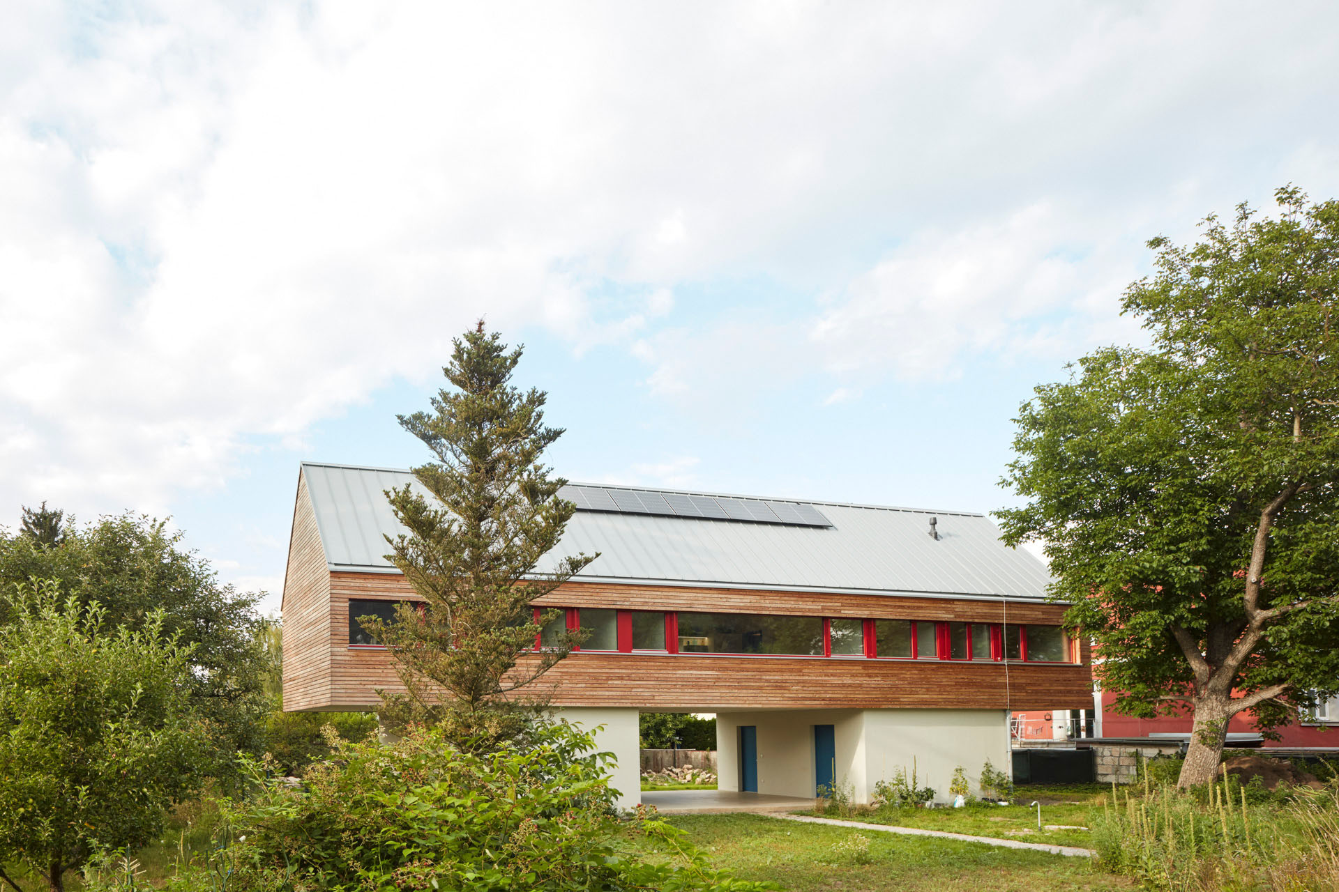 Jelikož novostavba stojí v záplavové oblasti řeky, hlavní výzvou a úkolem architektů bylo umístit obytné plochy nad úroveň stoleté vody. (Rodinný dům v Řevnicích, 0,5 studio)