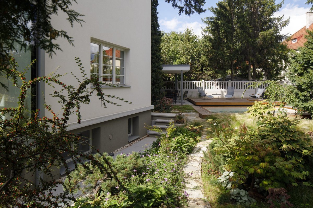 Zahrada je takřka zenová, je v ní mnoho druhů zeleně a nemá jen jednu úroveň, na jejím řešení spolupracovala architektka Anna Lochmanová. (Rekonstrukce prvorepublikové vily v Praze, Lenka Míková Architekti)