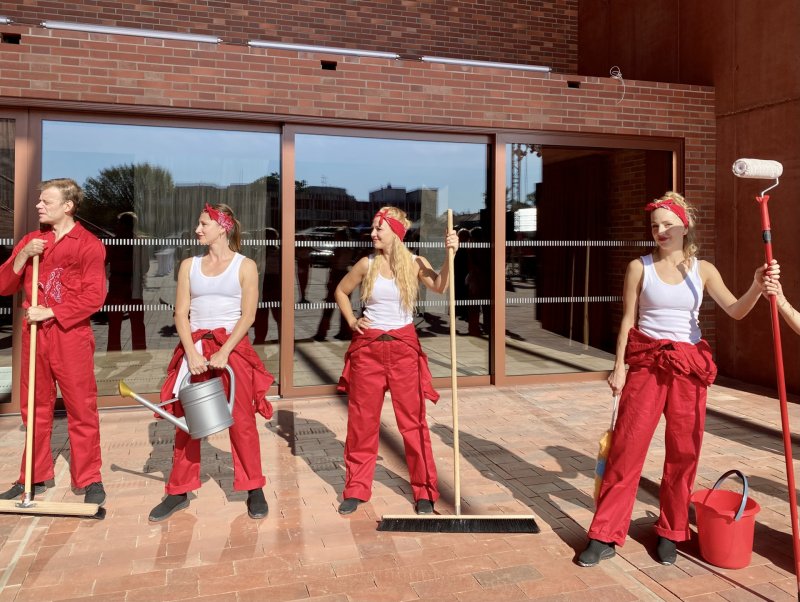 Otevření doprovázela performance uklízečů v overalech. Ovšem ještě večer před tím tu běhali reální pracovníci a dokončovali výdlažbu dvora.