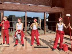 Otevření doprovázela performance uklízečů v overalech. Ovšem ještě večer před tím tu běhali reální pracovníci a dokončovali výdlažbu dvora.