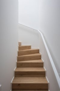 Jeden z bytů je mezonetový s dubovým schodištěm. (Terasový dvojdům v Krči, martin cenek architecture)